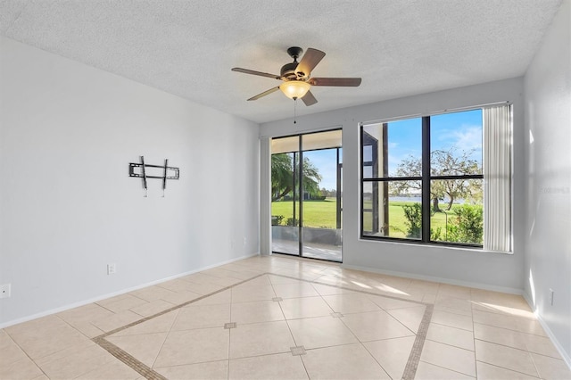 tiled spare room with ceiling fan and a textured ceiling