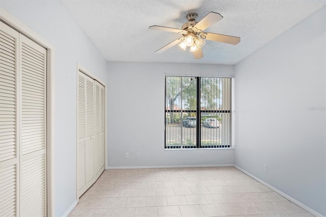 unfurnished bedroom with light tile patterned floors, a textured ceiling, and ceiling fan