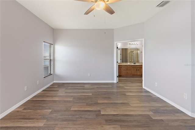 spare room with ceiling fan, sink, and dark wood-type flooring