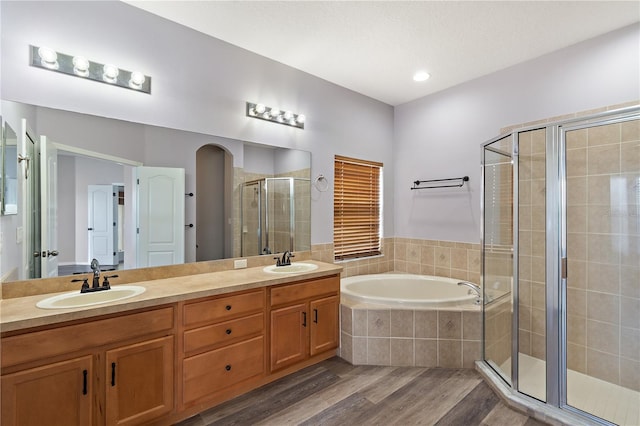 bathroom featuring vanity, wood-type flooring, and shower with separate bathtub