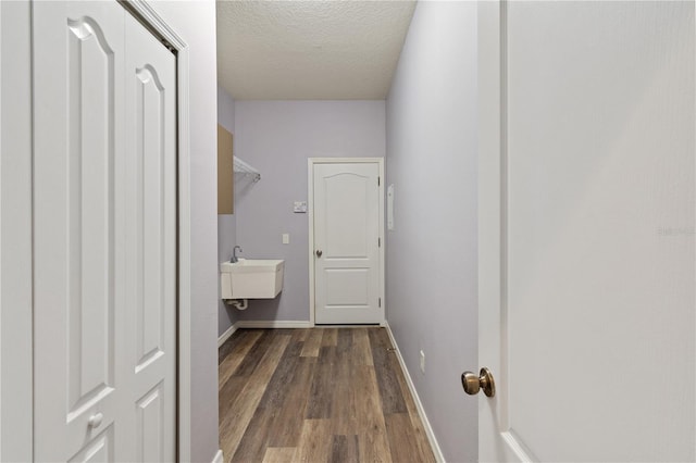 interior space featuring a textured ceiling, sink, and dark hardwood / wood-style floors