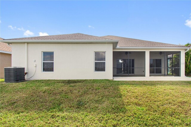 back of house with a sunroom, ceiling fan, a yard, and central air condition unit