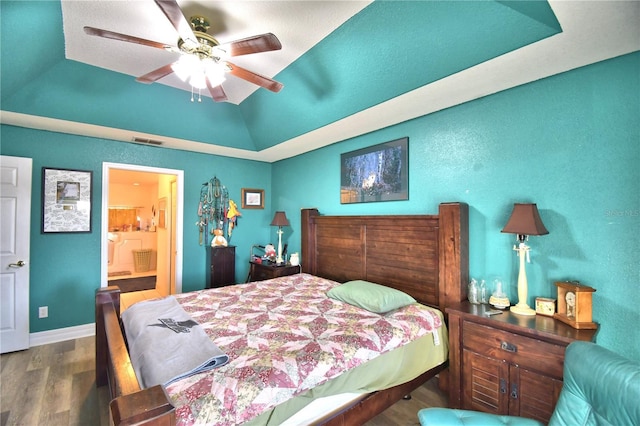 bedroom featuring hardwood / wood-style flooring, ceiling fan, a raised ceiling, and ensuite bathroom