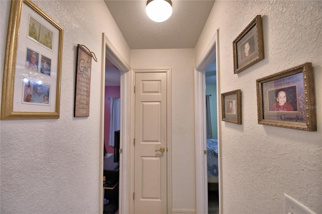 corridor featuring a textured ceiling