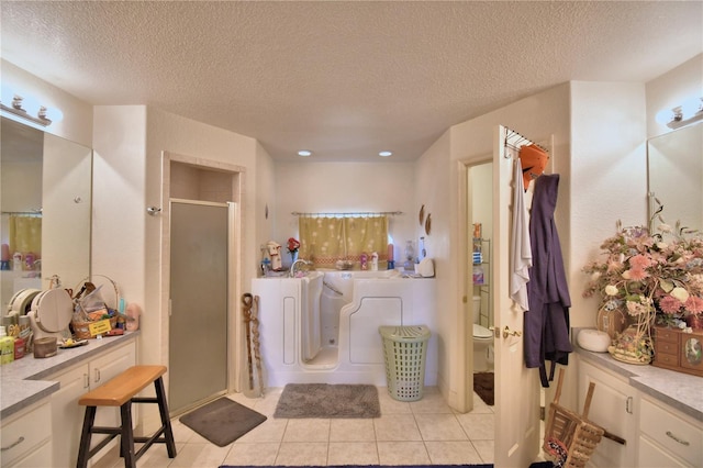 bathroom with walk in shower, vanity, a textured ceiling, tile patterned flooring, and toilet