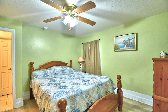 bedroom featuring hardwood / wood-style floors, a textured ceiling, and ceiling fan