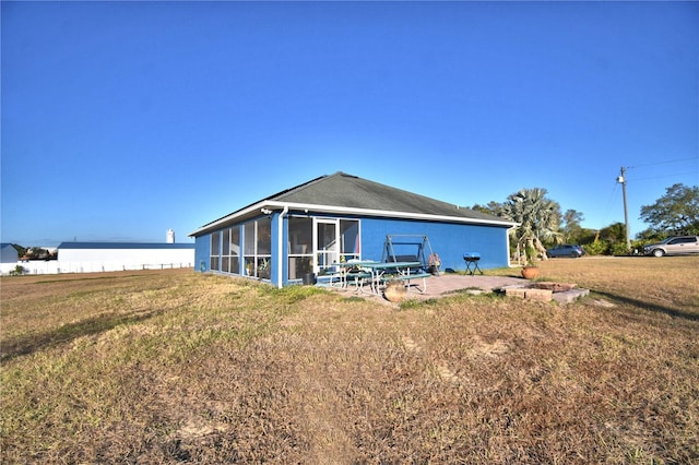 back of house with a yard, a patio, and a sunroom