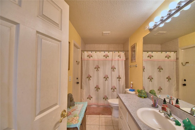 bathroom featuring vanity, tile patterned flooring, toilet, a textured ceiling, and walk in shower