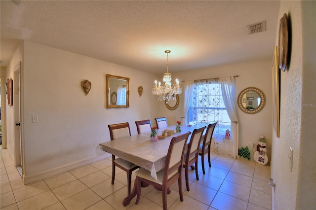 tiled dining room with a textured ceiling and an inviting chandelier