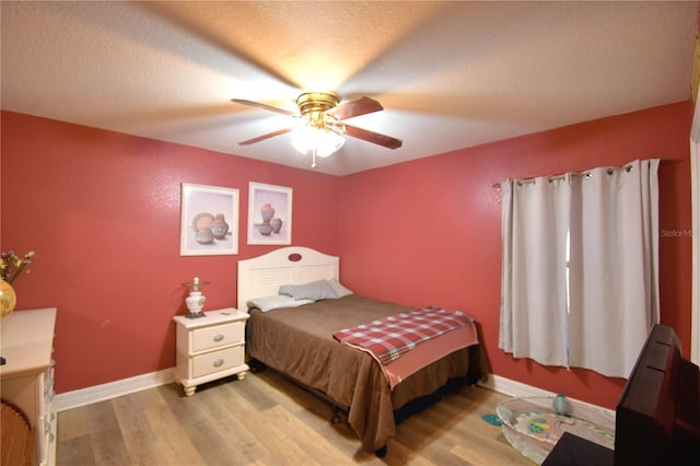 bedroom featuring ceiling fan, a textured ceiling, and light wood-type flooring