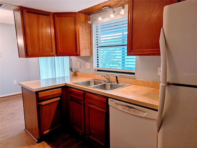 kitchen with kitchen peninsula, white appliances, sink, and dark wood-type flooring