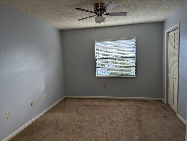 unfurnished bedroom with a closet, a textured ceiling, baseboards, and carpet flooring