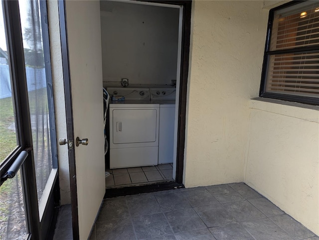 laundry room featuring washer and dryer and a textured wall