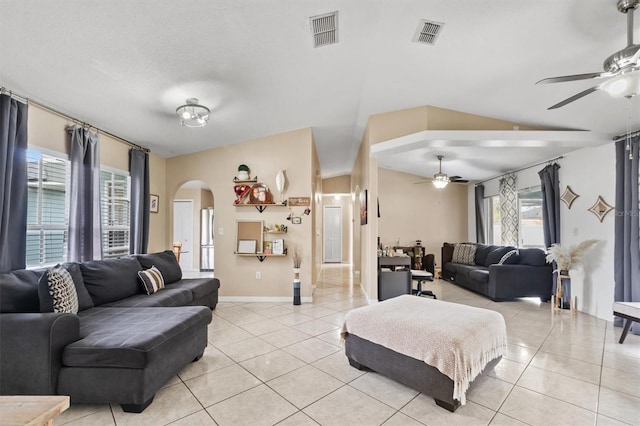 tiled living room with ceiling fan and vaulted ceiling