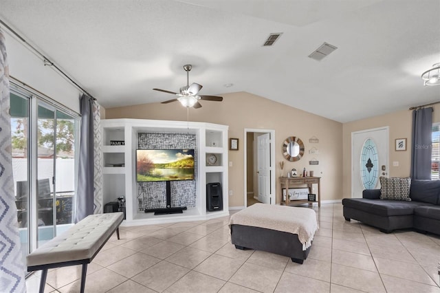 living room featuring built in shelves, ceiling fan, light tile patterned floors, and vaulted ceiling