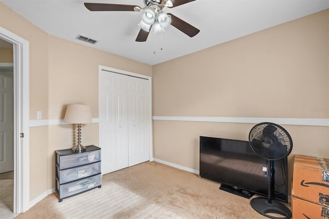 living area with light carpet and ceiling fan