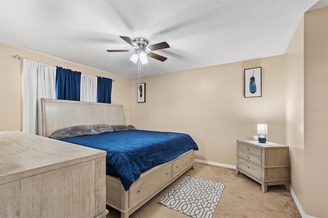 carpeted bedroom featuring ceiling fan and a textured ceiling