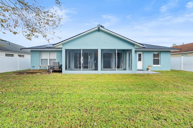 rear view of property featuring a lawn and a sunroom