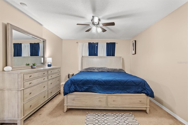 bedroom with light carpet, a textured ceiling, and ceiling fan