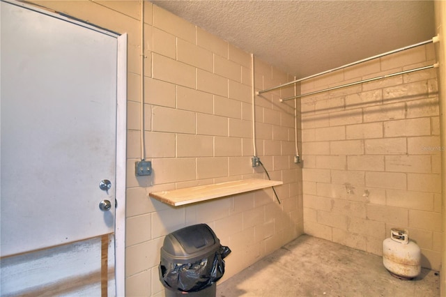 interior space with a shower, a textured ceiling, and concrete floors