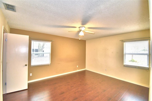 empty room with a textured ceiling, dark hardwood / wood-style floors, and ceiling fan