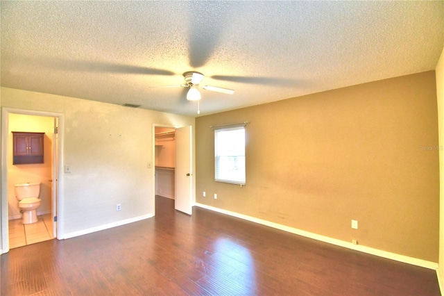 spare room with ceiling fan, dark hardwood / wood-style flooring, and a textured ceiling