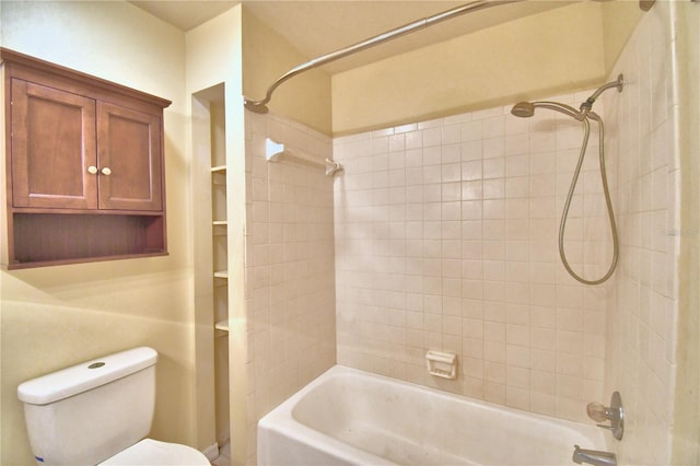 bathroom with toilet and tiled shower / bath