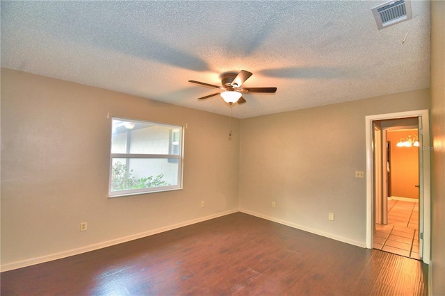 spare room featuring a textured ceiling, ceiling fan, and dark hardwood / wood-style floors