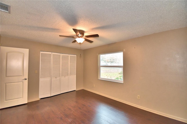 unfurnished bedroom with a textured ceiling, ceiling fan, and dark wood-type flooring