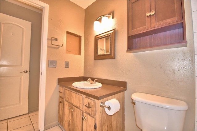 bathroom with tile patterned flooring, vanity, and toilet