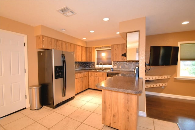 kitchen featuring sink, light brown cabinets, stainless steel fridge, decorative backsplash, and light tile patterned flooring