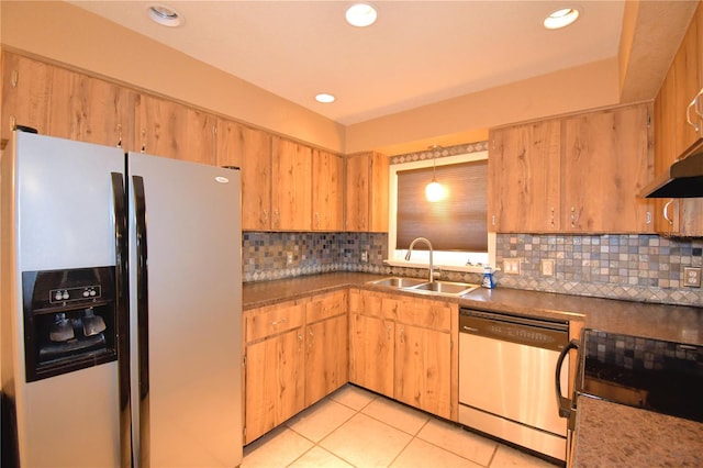 kitchen with appliances with stainless steel finishes, backsplash, sink, light tile patterned floors, and decorative light fixtures