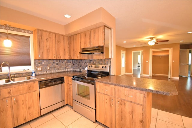 kitchen with sink, light tile patterned floors, stainless steel appliances, and decorative light fixtures