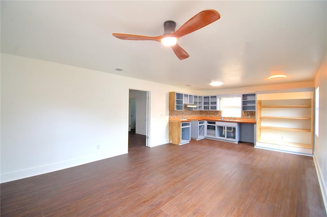 unfurnished living room featuring dark hardwood / wood-style flooring and ceiling fan