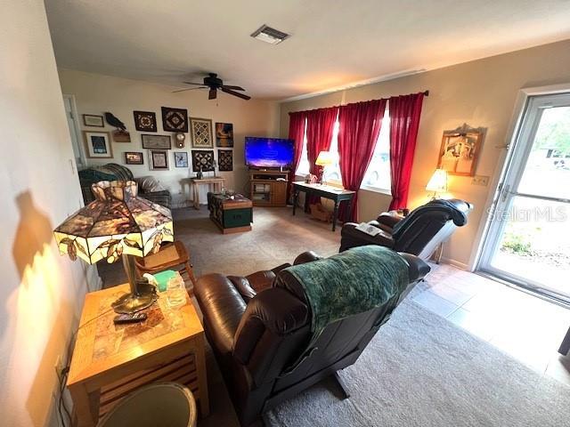 tiled living room with ceiling fan