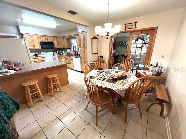 dining space with a notable chandelier and light tile patterned flooring