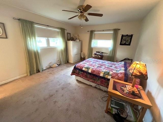 bedroom with carpet flooring, multiple windows, and ceiling fan