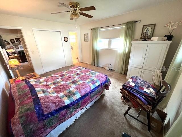 carpeted bedroom with a closet and ceiling fan