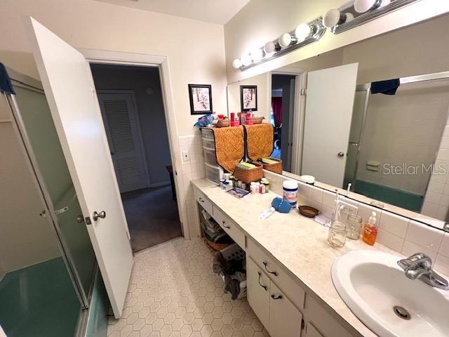 bathroom with vanity and a shower with shower door