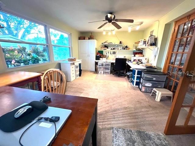 home office featuring light carpet and ceiling fan