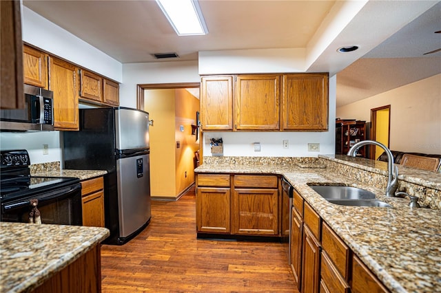 kitchen featuring light stone countertops, sink, stainless steel appliances, and dark hardwood / wood-style floors