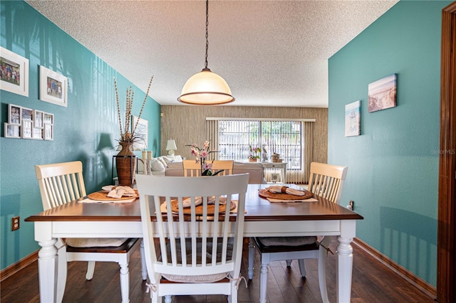 dining space featuring dark hardwood / wood-style flooring and a textured ceiling