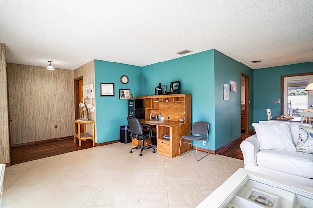 home office featuring wood-type flooring and a textured ceiling