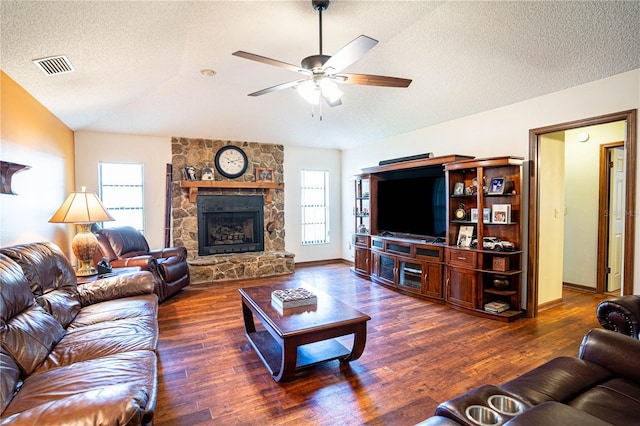 living room with a fireplace, a textured ceiling, dark hardwood / wood-style flooring, and lofted ceiling