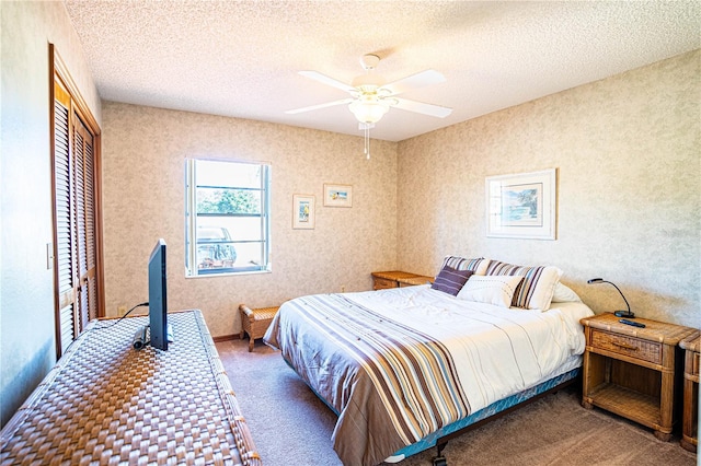 carpeted bedroom featuring ceiling fan, a closet, and a textured ceiling