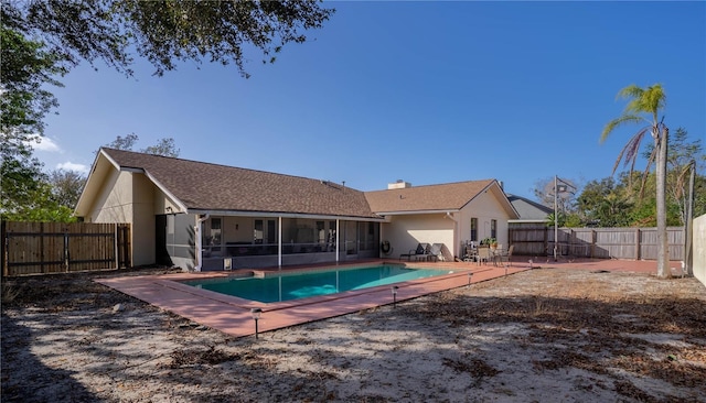 rear view of property with a fenced in pool and a sunroom