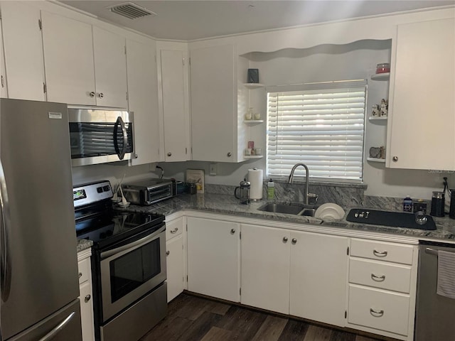 kitchen with light stone countertops, appliances with stainless steel finishes, dark hardwood / wood-style flooring, sink, and white cabinets