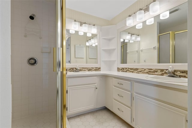 bathroom featuring a shower with shower door, vanity, and tasteful backsplash