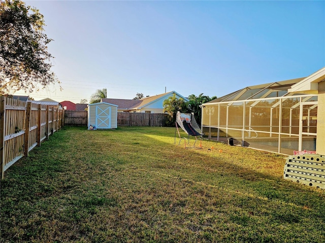 view of yard with glass enclosure and a storage shed