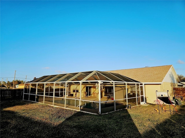 back of property featuring a yard, a patio, and a lanai